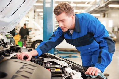 auto mechanic examining a vehicle in an auto shop