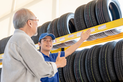 auto mechanic showing customer a variety of car tires