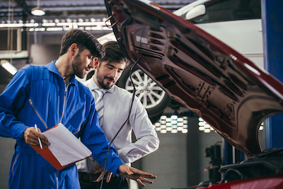 ​​auto mechanic discussing car repairs with a customer