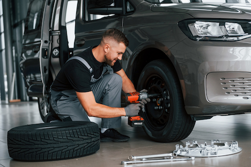 auto mechanic changing a car tire during service