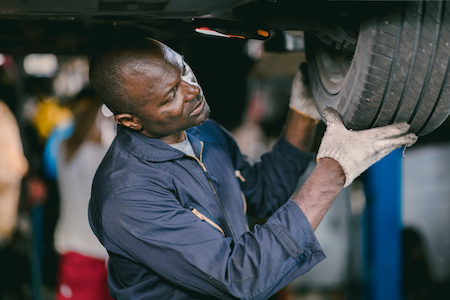 auto mechanic inspecting car tire