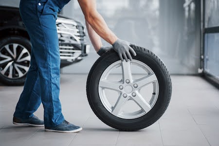 mechanic holding a tire at a Fairfax tire shop